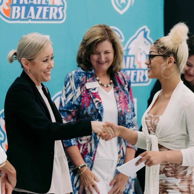 Forsyth Tech President Dr. Janet Spriggs looks on as Tricia McManus, superintendent of Winston-Salem Forsyth County Schools, shakes hands with Sarah Lusano, a graduate of Reynolds High School.